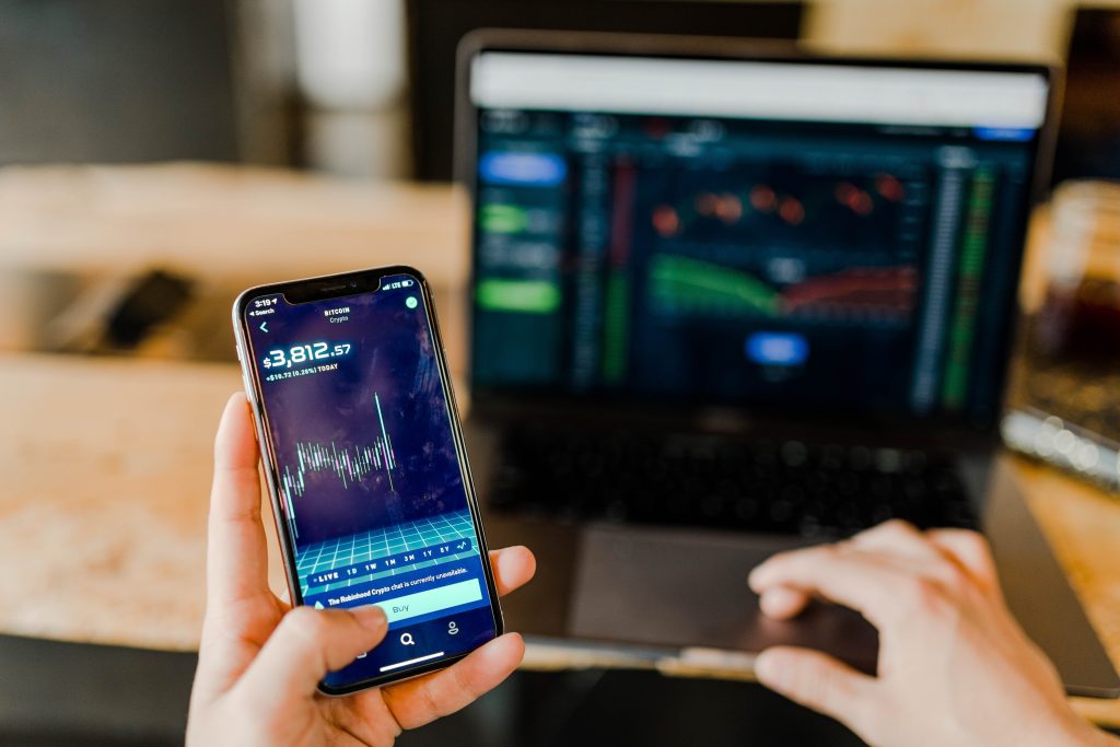 Imamge of a laptop and cellphone showing forex trading graphs